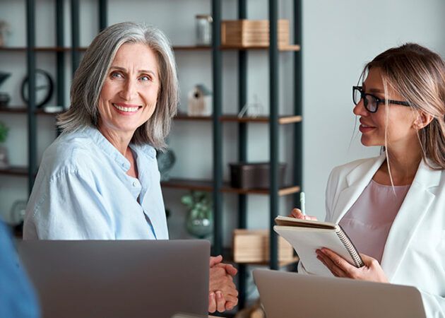 Younger and older woman working together in office