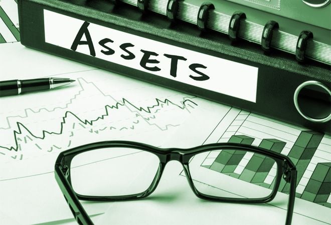 foler labelled 'assets' on desk with paperwork