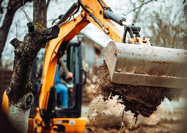 Worker using excavator and bulldozer for landscaping works