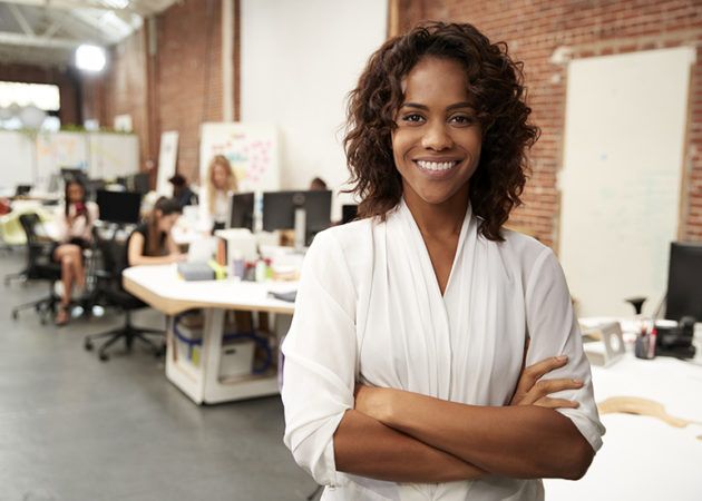 Proud woman standing in office showing confidence