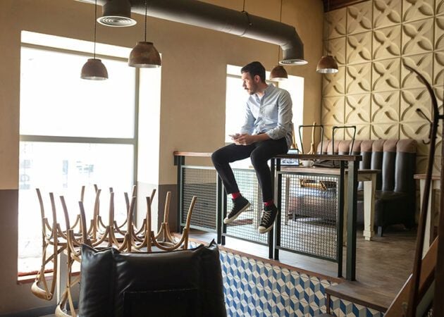 Young restaurant owner sitting in empty, closed venue