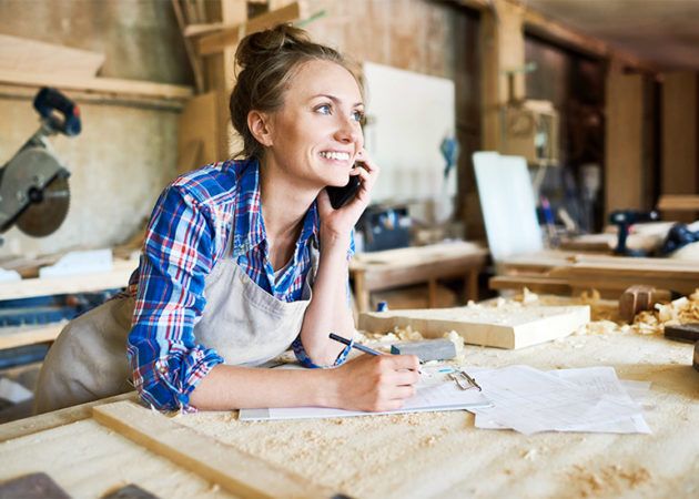 Female tradie on phone in workshop