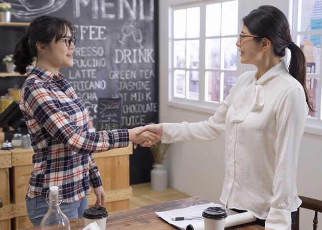Cafe owner shaking hands with new employee