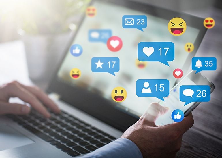 Social media reactions on laptop and phone