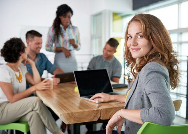 Woman in team meeting looking back at camera