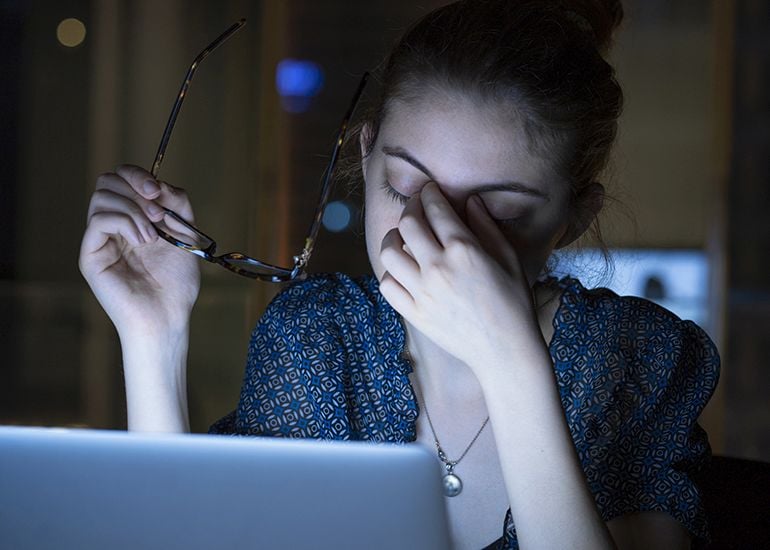 Tired young woman working on computer