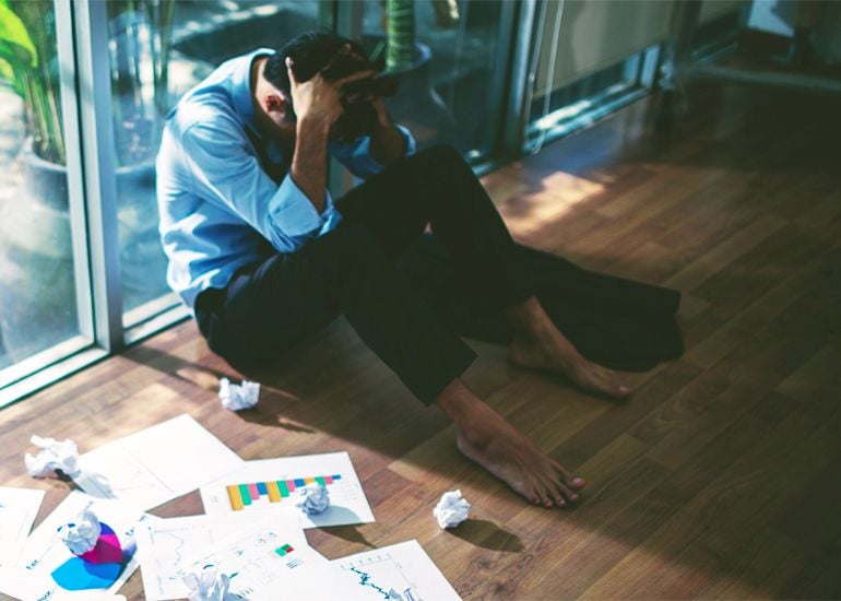 Troubled business man sitting with head in hands