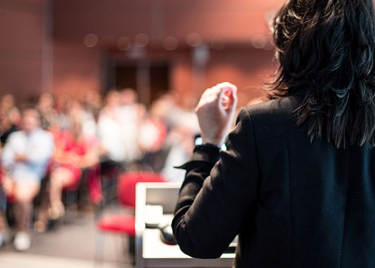 WOman giving speech in conference room