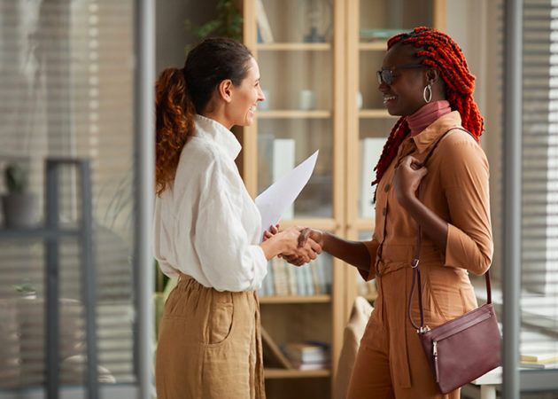 Two women in office shaking hands after interview