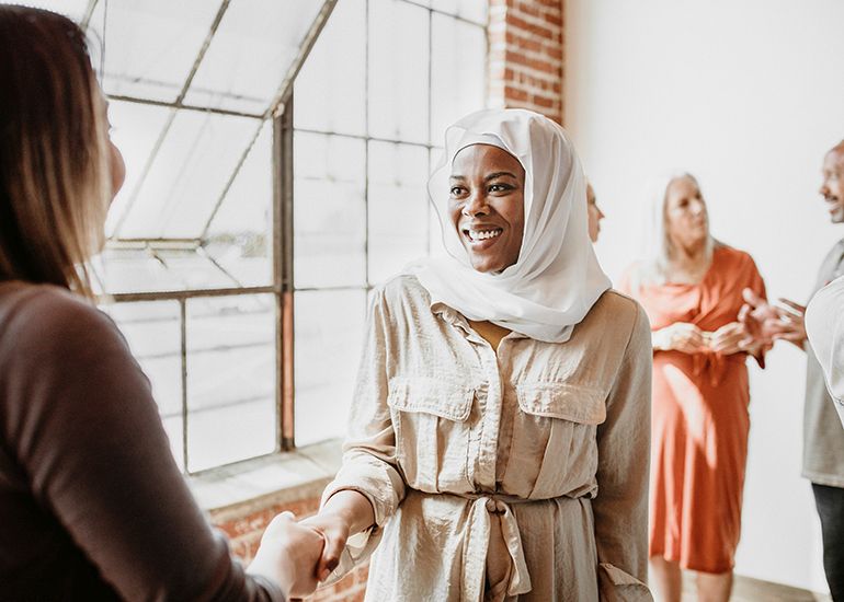 Women shaking hands at community meeting