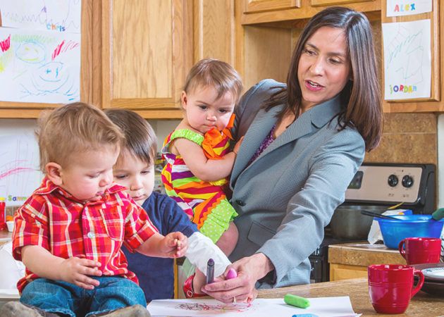 mother in business suit with three children in kitchen
