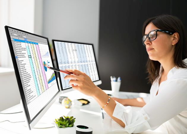 woman with glasses looking at spreadsheet