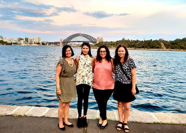 Tash Foura member - four friend stand in a line in front of the harbour bridge