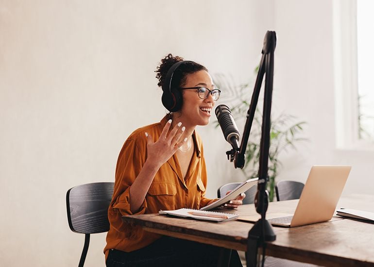 Woman using microphone to record podcast