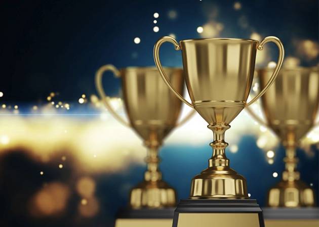 a trio of award trophies against a blurred background