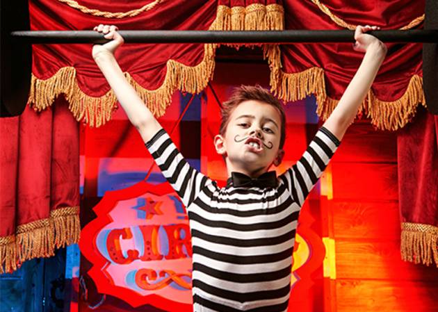 circus kid in stripy outfit lifts a barbell- benchmark concept