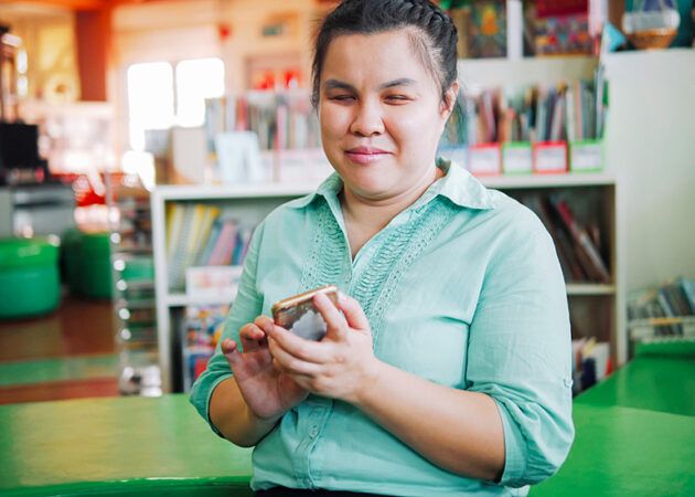 Blind woman using smartphone in workplace