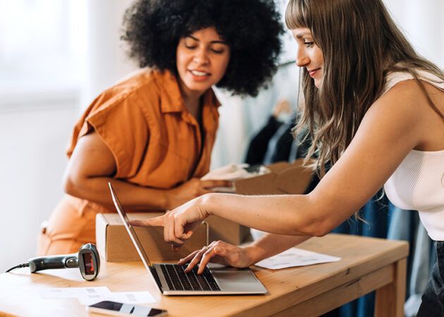 clothing store owners on laptop