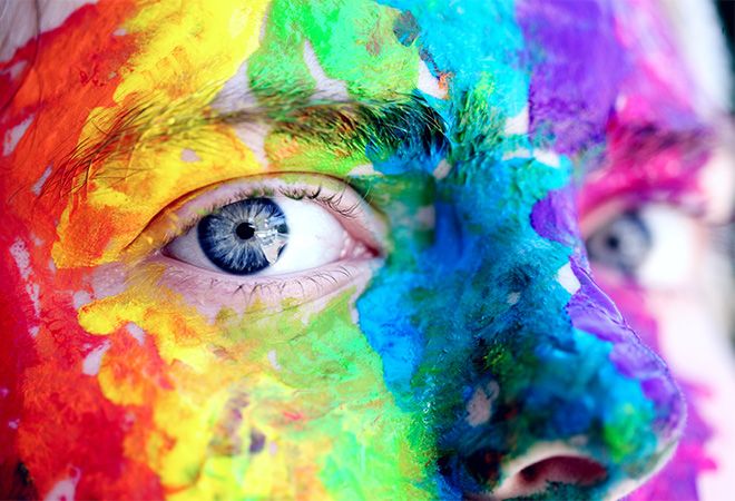 face covoered in thick, brightly coloured paints