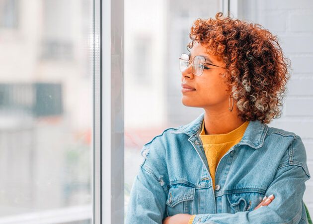 Woman looking thoughtfully out office window
