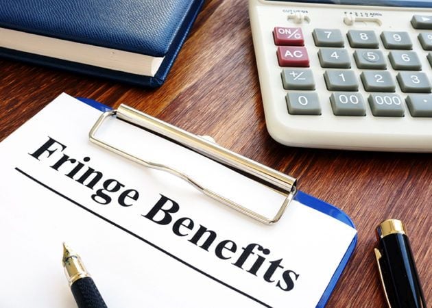 calculator and diary next to notepad with the words 'fringe benefits'