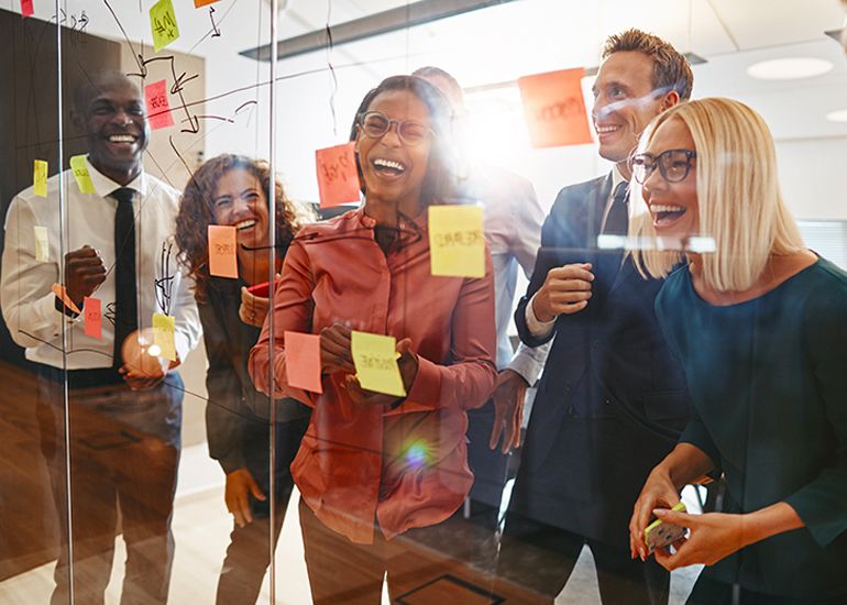 Happy, laughing team mates in office