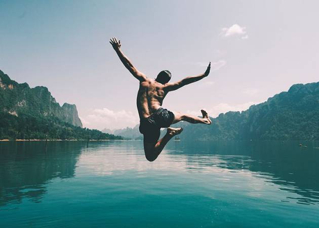 happy summer holiday moment man leaping into lake