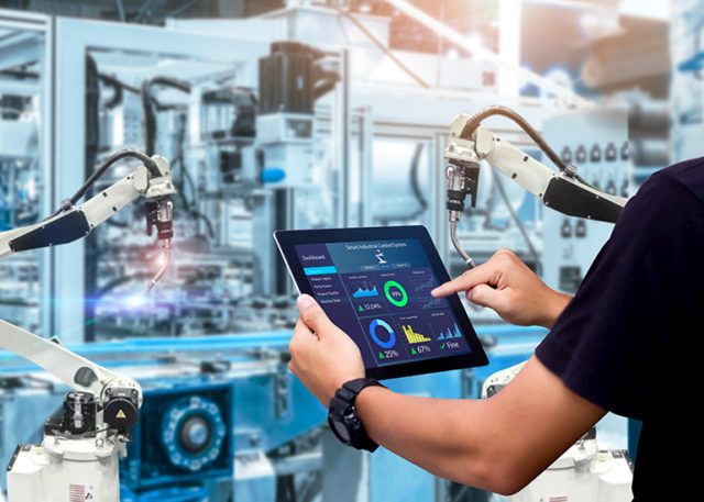 Man using digital tablet to control robotic arms