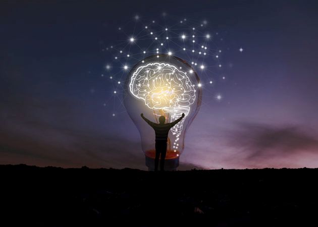 Silhouette of a man standing in front of large light globe