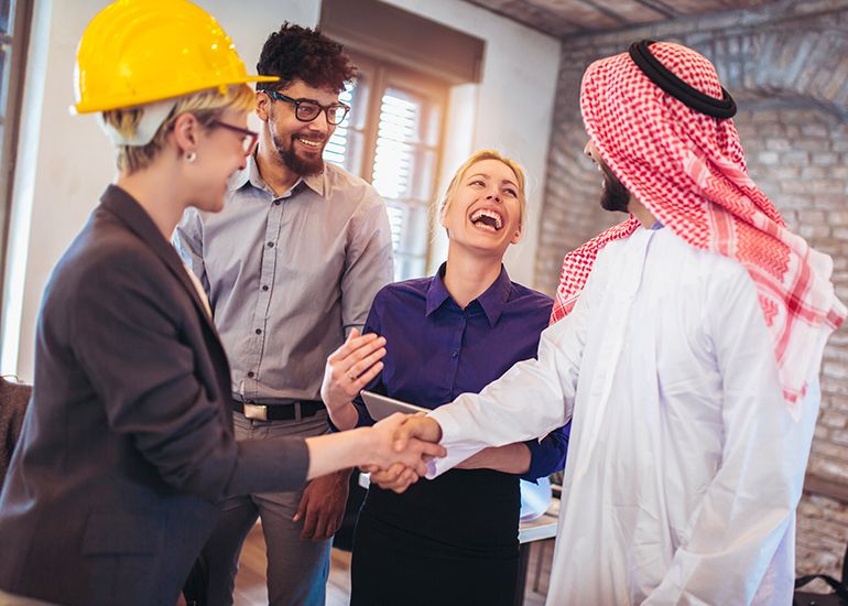 Multicultural group of business people laughing and shaking hands
