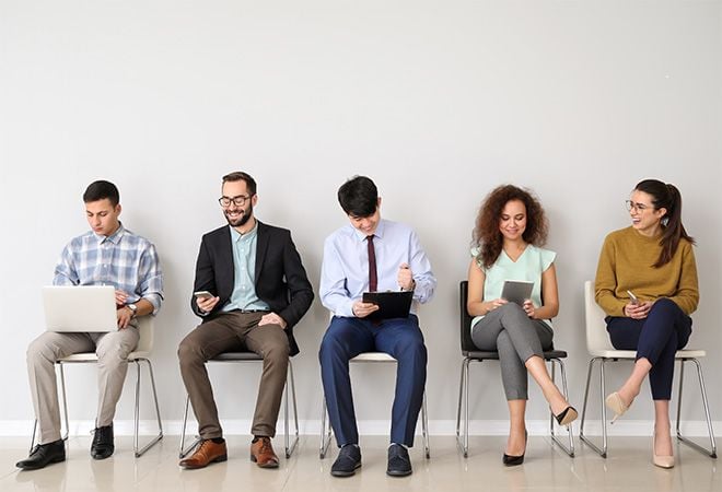 Five people sitting inc hairs while waiting for job interview