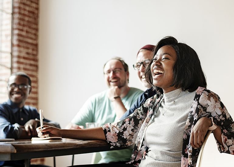 Happy team members laughing in work meeting