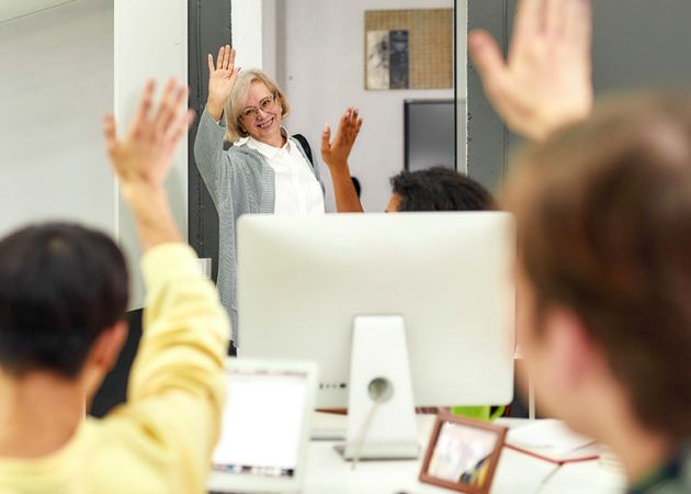Woman waving to workmates as she leaves the office