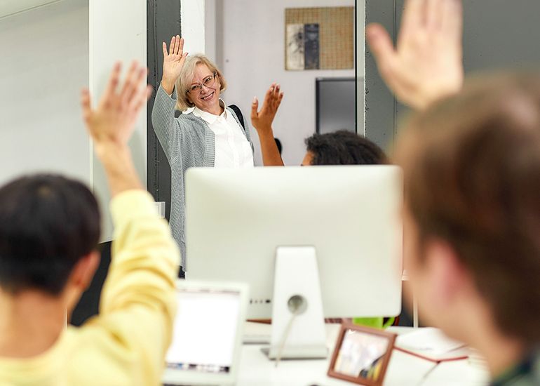 Woman waving to workmates as she leaves the office