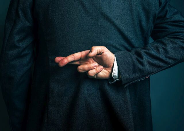 Man with fingers crossed behind back, telling lies