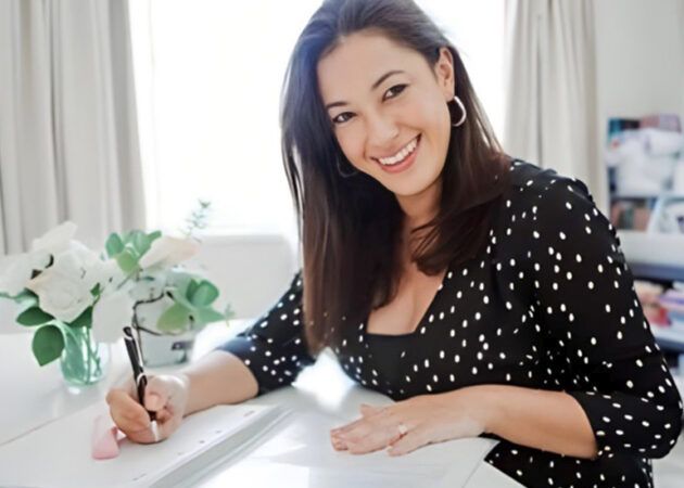 melissa chalk headshot brown haired woman sits at desk smiles at camera