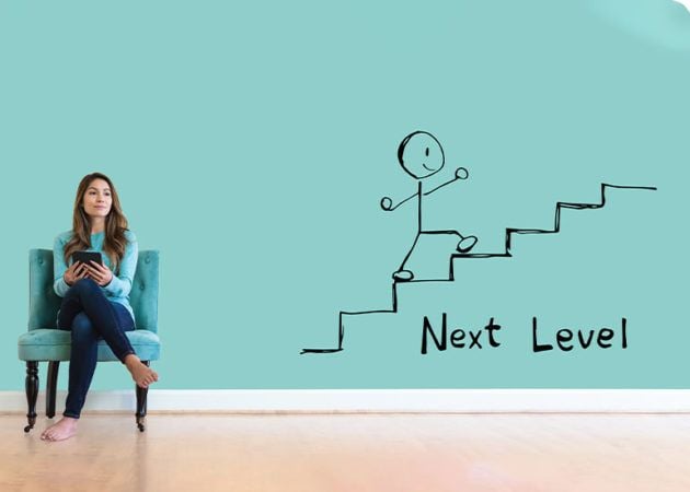 woman in chair next to drawing of stairs on wall and the words 'next level'