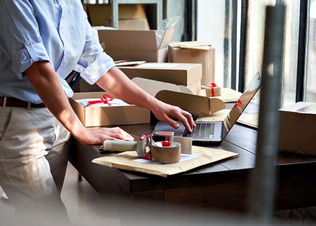Woman using laptop digital software to manage stock orders