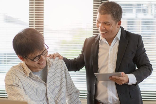 Suuportive boss with hand on employee's shoulder