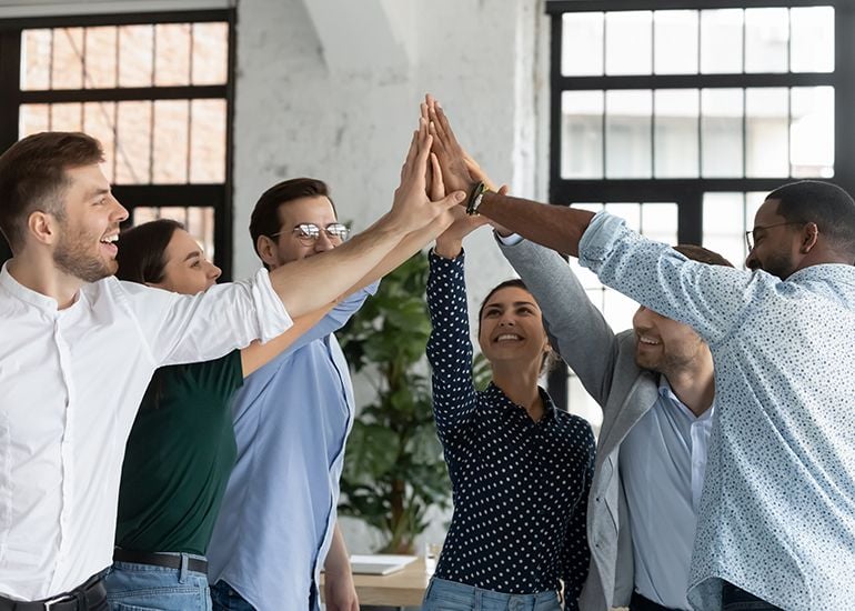 Happy employees high fiving their success