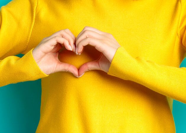 Woman forming a love heart with her hands in front of her heart