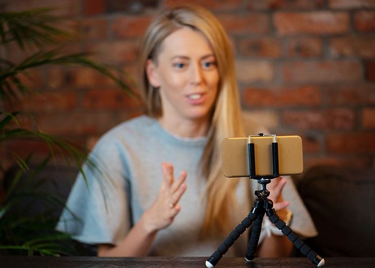 Woman video recording herself using a mobile phone