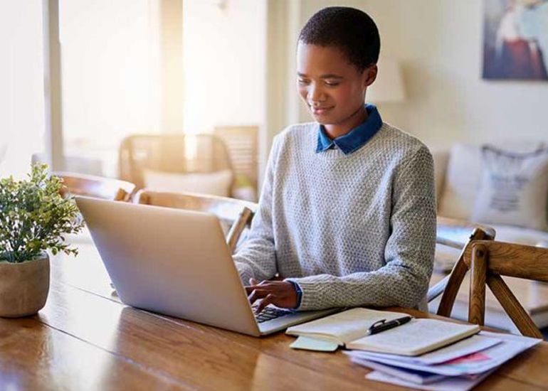 Women working remotely at home from dining table