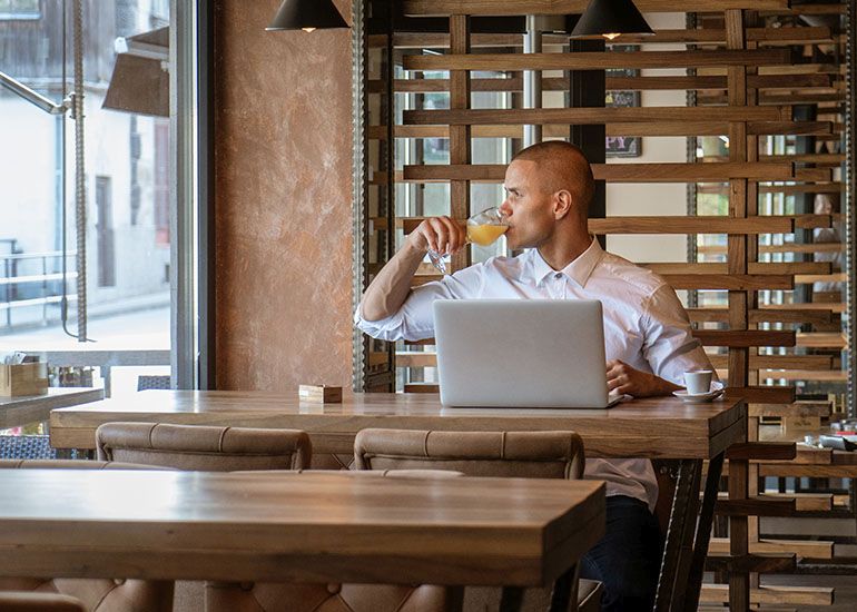Man working on laptop in cafe