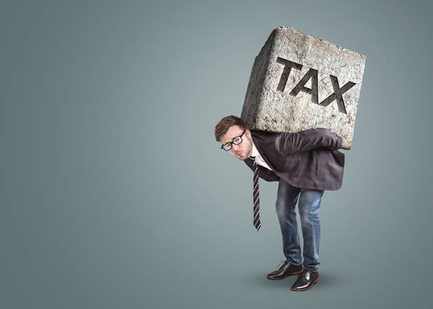 man doublked over with large tax block weighing him down