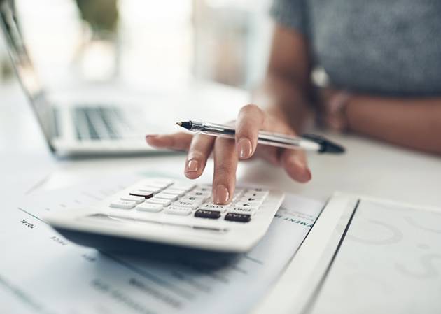 woman uses calculator for eofy payroll calculations