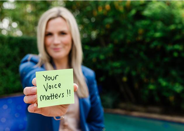 Casey Squires holding a postit that says your voice matters