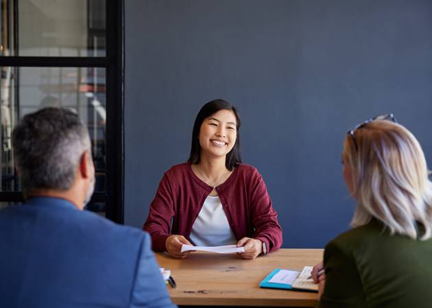 young woman sitting at table with employers