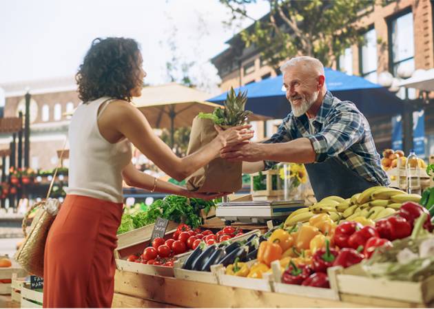 Small business owner selling fruit at a market stall