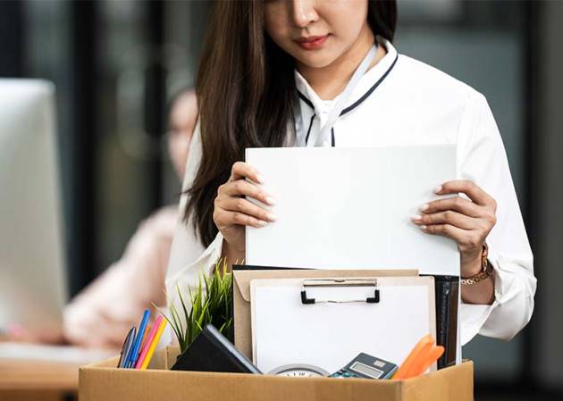 A woman packs a bag after job redundancy